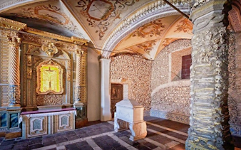 Capela dos Ossos interior with bone-adorned walls and ornate altar, Évora, Portugal.