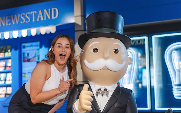 Woman posing with Monopoly mascot at Monopoly Dreams Melbourne.