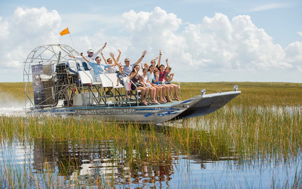 Airboat tour with passengers in Orlando wetlands, part of the Explorer City Pass experience.