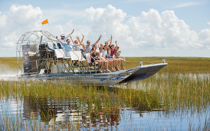 Airboat tour with passengers in Orlando wetlands, part of the Explorer City Pass experience.