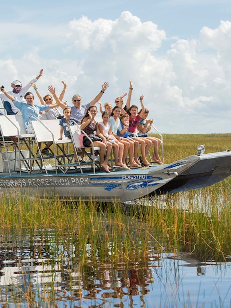 Airboat tour with passengers in Orlando wetlands, part of the Explorer City Pass experience.