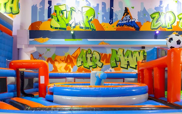 Air Maniax inflatable park with colorful play structures and graffiti art.
