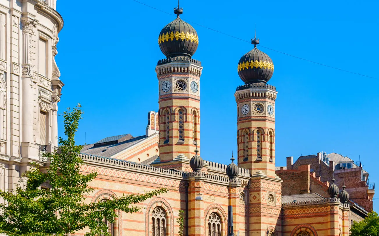Dohány Street Synagogue towers in Budapest under clear blue sky.