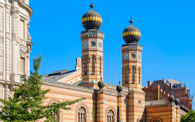 Dohány Street Synagogue towers in Budapest under clear blue sky.