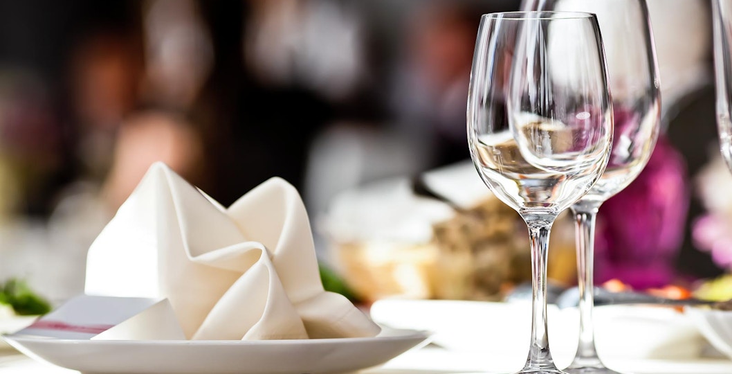 Elegant table setting with wine glasses and folded napkin at a fine dining restaurant.
