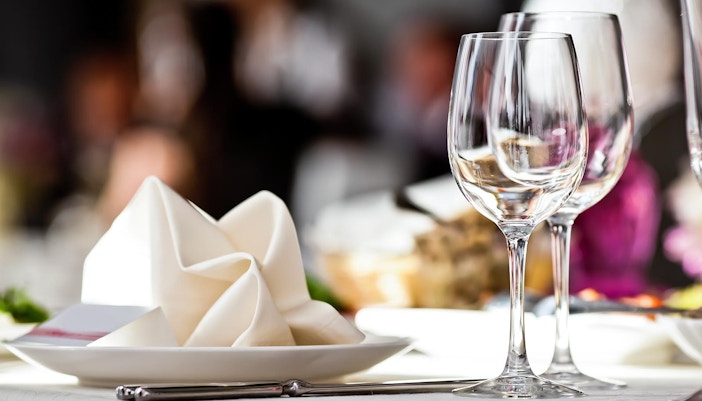 Elegant dining setup with wine glasses and cutlery at a fine dining restaurant in Paris.