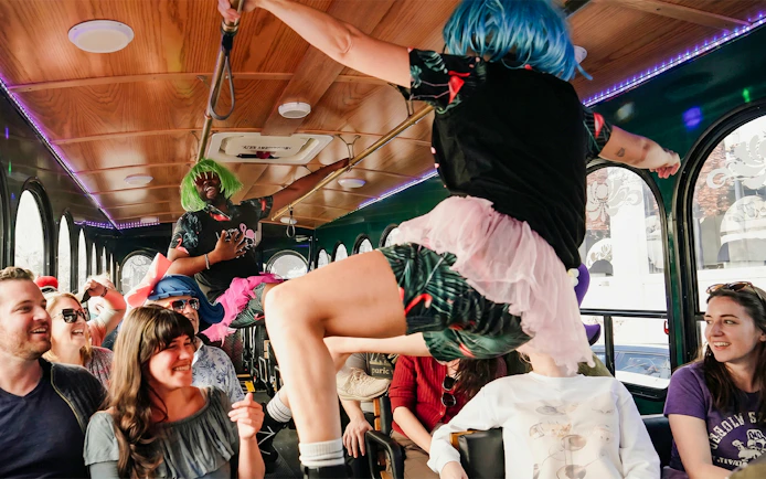 Performers in colorful wigs entertain passengers on the Nashville For Morons Comedy Trolley Tour.
