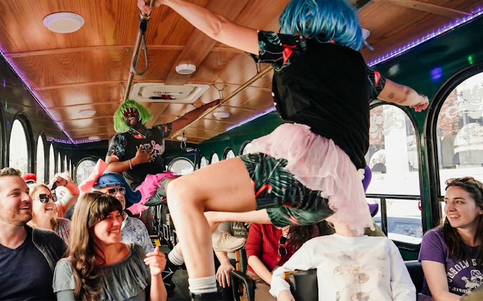 Performers in colorful wigs entertain passengers on the Nashville For Morons Comedy Trolley Tour.