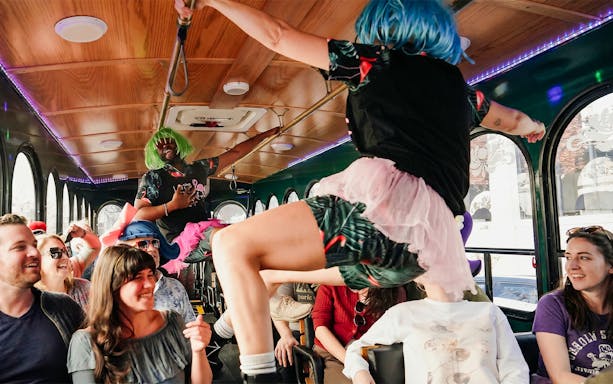 Performers in colorful wigs entertain passengers on the Nashville For Morons Comedy Trolley Tour.