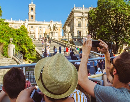 Tourists on HOHO bus capturing photos of Capitoline Hill, Rome.
