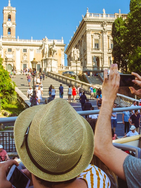 Tourists on HOHO bus capturing photos of Capitoline Hill, Rome.