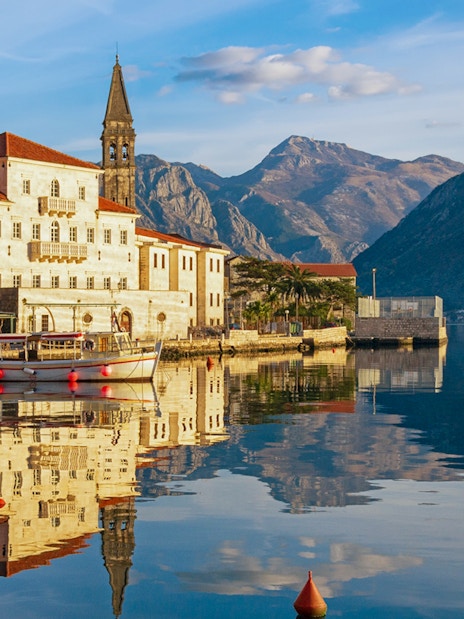 Perast town waterfront with historic buildings and mountains in Montenegro.
