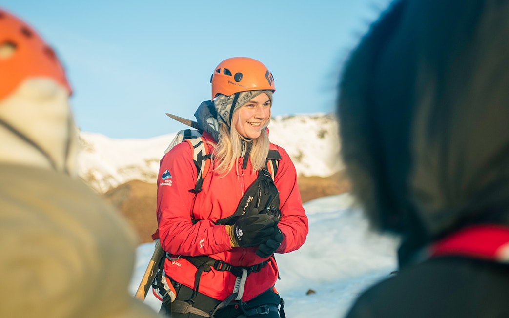 Guests hiking on Vatnajökull Glacier in Iceland, wearing helmets and winter gear.