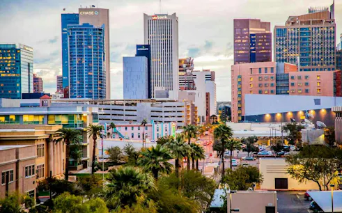 Downtown Phoenix skyline with modern skyscrapers and palm trees, part of the Phoenix Rising Mystery tour.