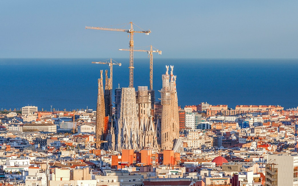 Sagrada Familia with cranes in Barcelona, view from Montjuic cable car.
