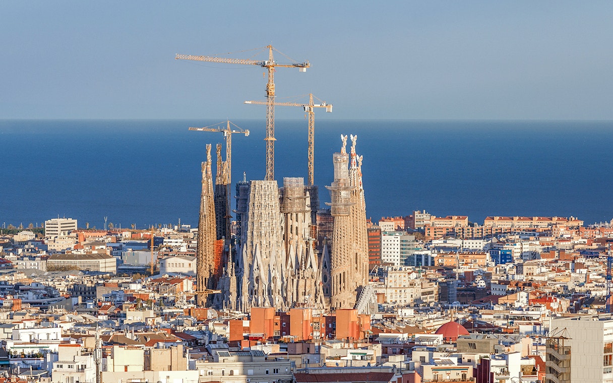 Sagrada Familia with cranes in Barcelona, view from Montjuic cable car.