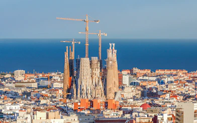 Sagrada Familia with cranes in Barcelona, view from Montjuic cable car.