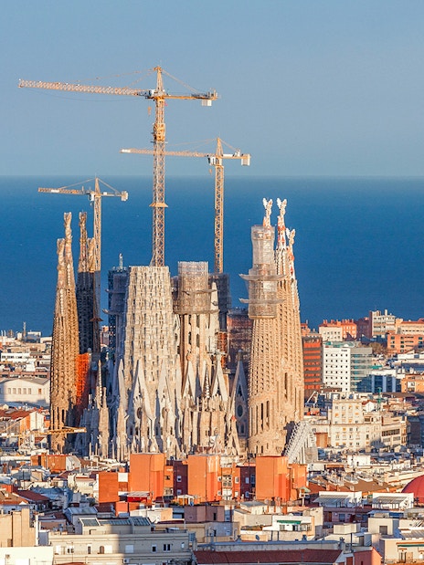 Sagrada Familia with cranes in Barcelona, view from Montjuic cable car.