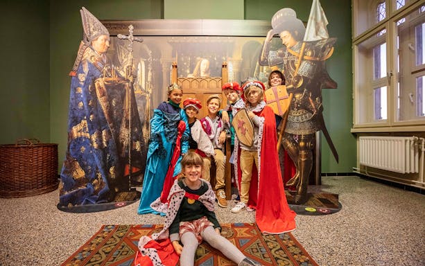 Children dressed up in medieval costumes at the Historium Brugge