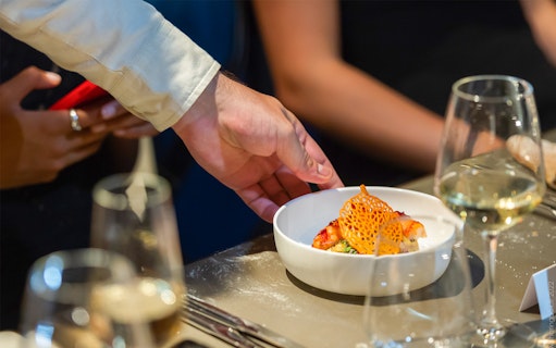 Waiter serving a gourmet dish at Madame Brasserie, Paris.