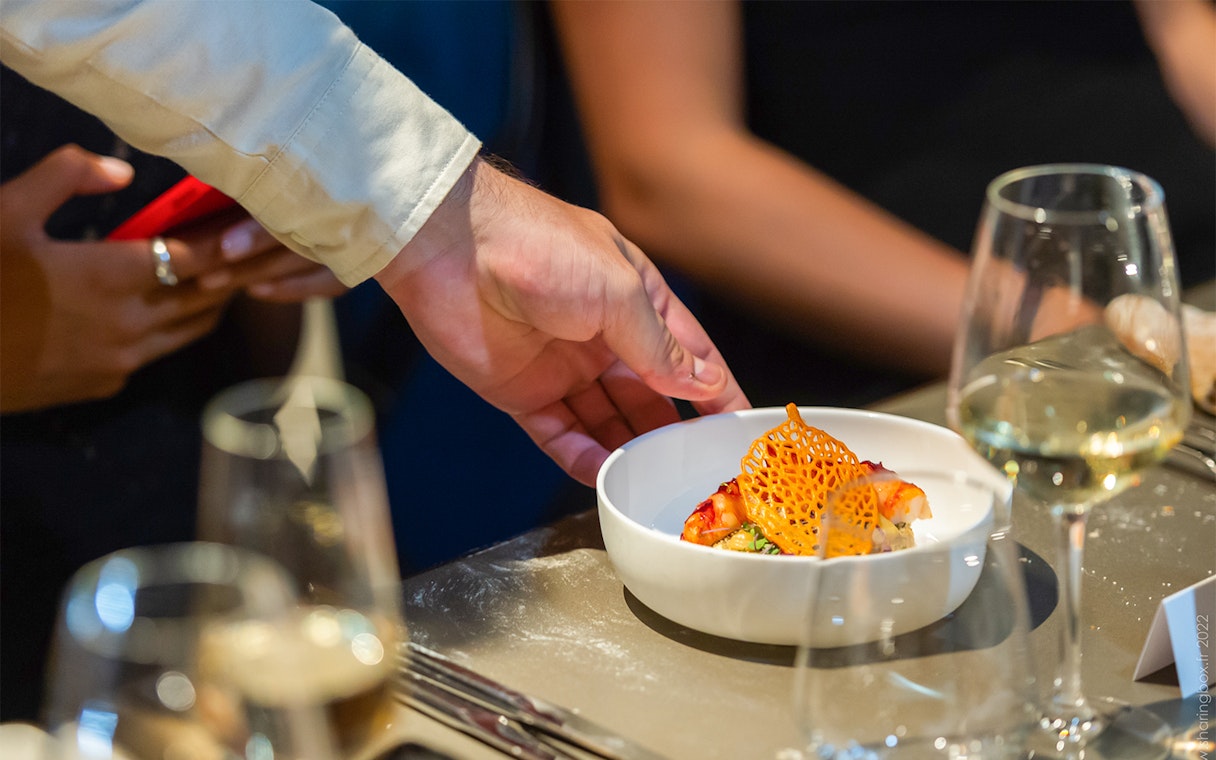 Waiter serving a gourmet dish at Madame Brasserie, Paris.