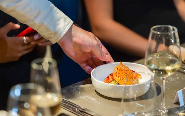 Waiter serving a gourmet dish at Madame Brasserie, Paris.