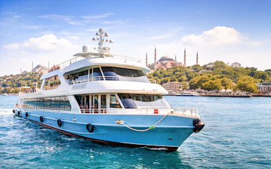 Cruise ship on Bosphorus with Hagia Sophia in Istanbul background.