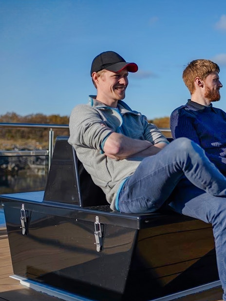 People relaxing on deck during Silent Trollfjord Cruise, Lofoten.