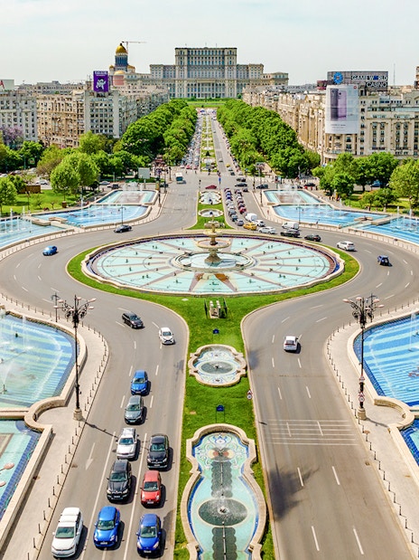 Aerial view of Unirii Square fountains and traffic in Bucharest, Romania.