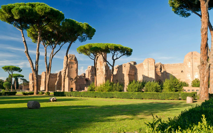 Baths of Caracalla ruins with pine trees in Rome, Italy, during summer.