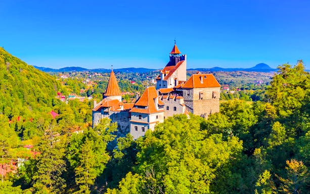 Bran Castle surrounded by lush greenery in Romania.