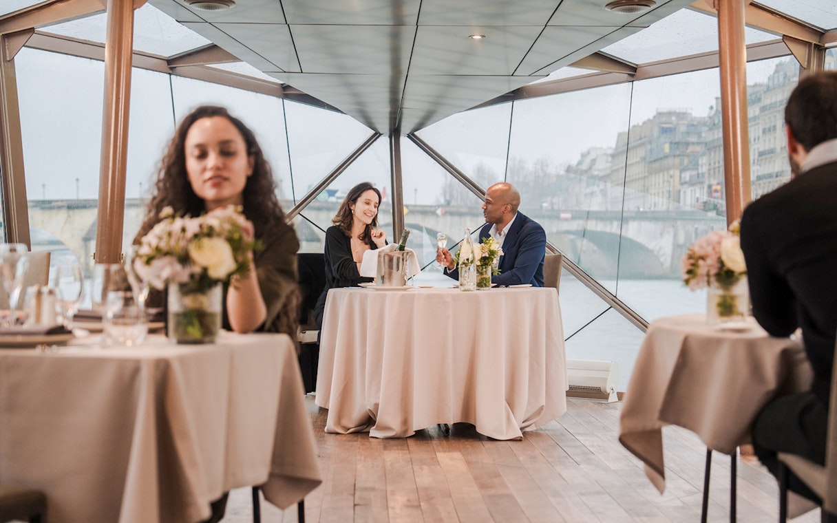 Couple dining on Seine River sightseeing lunch cruise in Paris.