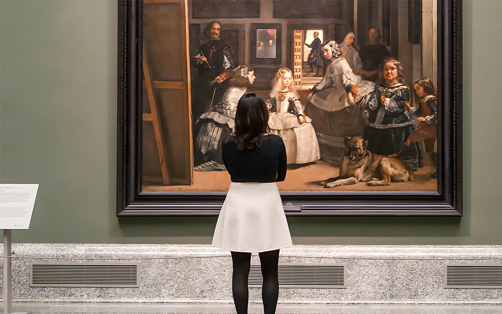 Visitor admiring Velázquez's "Las Meninas" at the Prado Museum in Madrid.