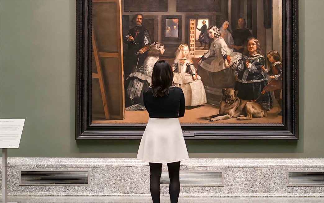 Visitor admiring Velázquez's "Las Meninas" at the Prado Museum in Madrid.