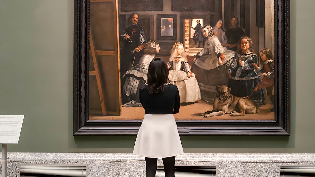 Visitor admiring Velázquez's "Las Meninas" at the Prado Museum in Madrid.