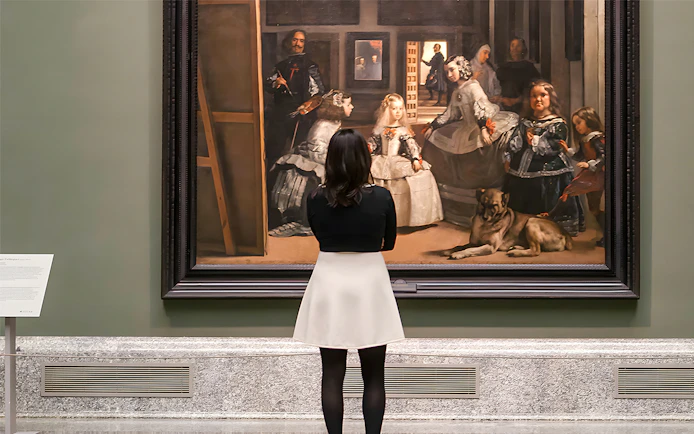 Visitor admiring Velázquez's "Las Meninas" at the Prado Museum in Madrid.