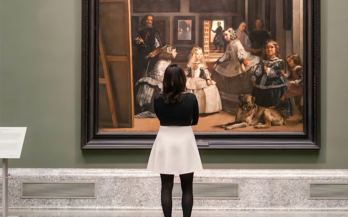 Visitor admiring Velázquez's "Las Meninas" at the Prado Museum in Madrid.