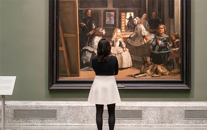 Visitor admiring Velázquez's "Las Meninas" at the Prado Museum in Madrid.
