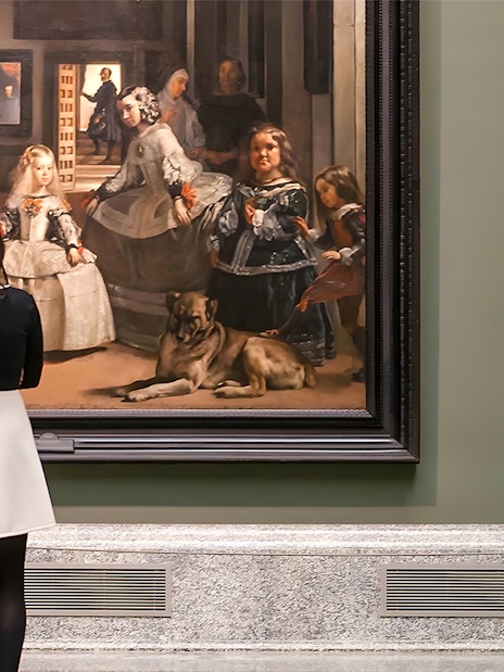 Visitor admiring Velázquez's "Las Meninas" at the Prado Museum in Madrid.