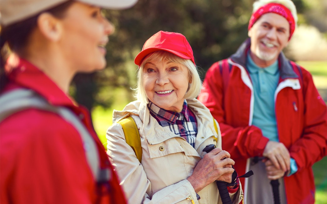 Blonde woman smiling while listening to a guide during a group hike.