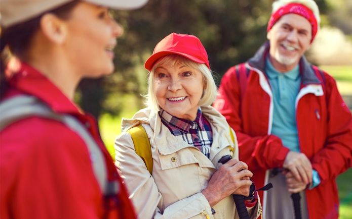 Blonde woman smiling while listening to a guide during a group hike.
