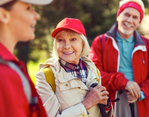 Blonde woman smiling while listening to a guide during a group hike.
