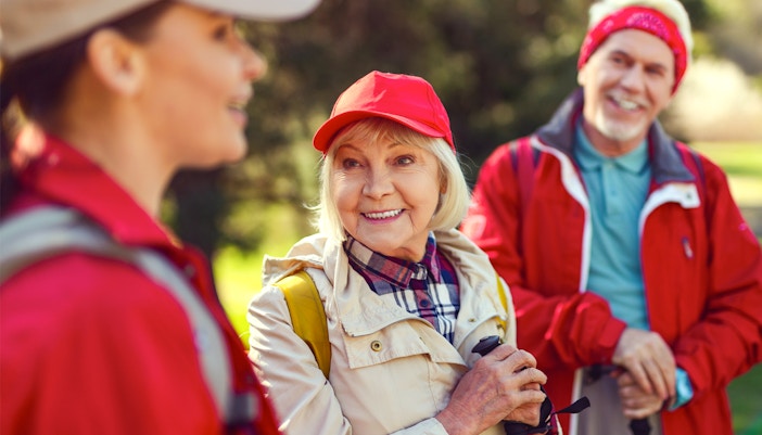 Blonde woman smiling while listening to a guide during a group hike