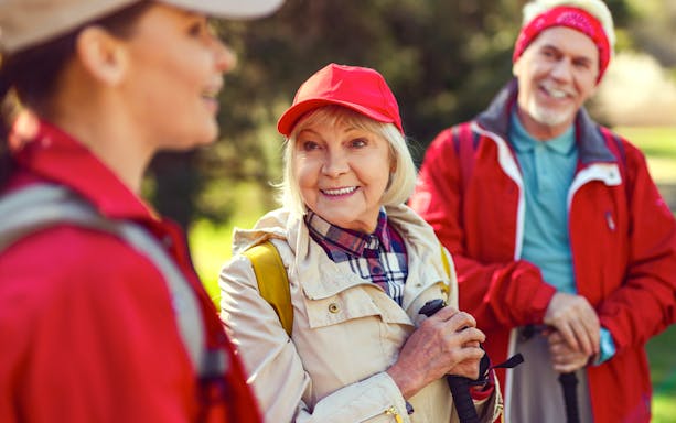 Blonde woman smiling while listening to a guide during a group hike.