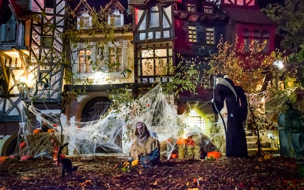Haunted house with cobwebs and pumpkins at Astérix Parc Halloween event.