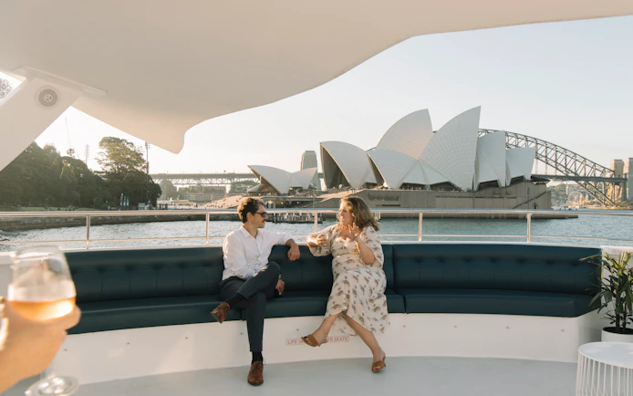 Couple enjoying Sydney Harbour dinner cruise with Opera House view.