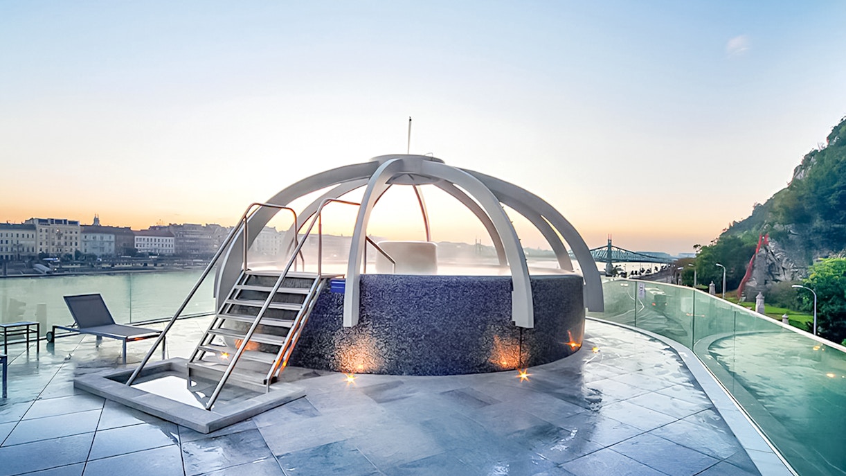 Rooftop pool at Rudas Baths with city and river view in Budapest.