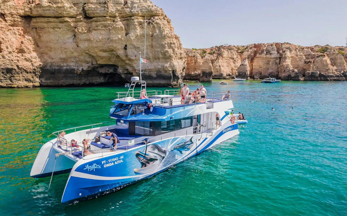 Catamaran with tourists near Benagil Caves, Algarve, Portugal.