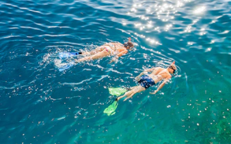 Couple snorkeling in the clear waters of the Blue Lagoon.