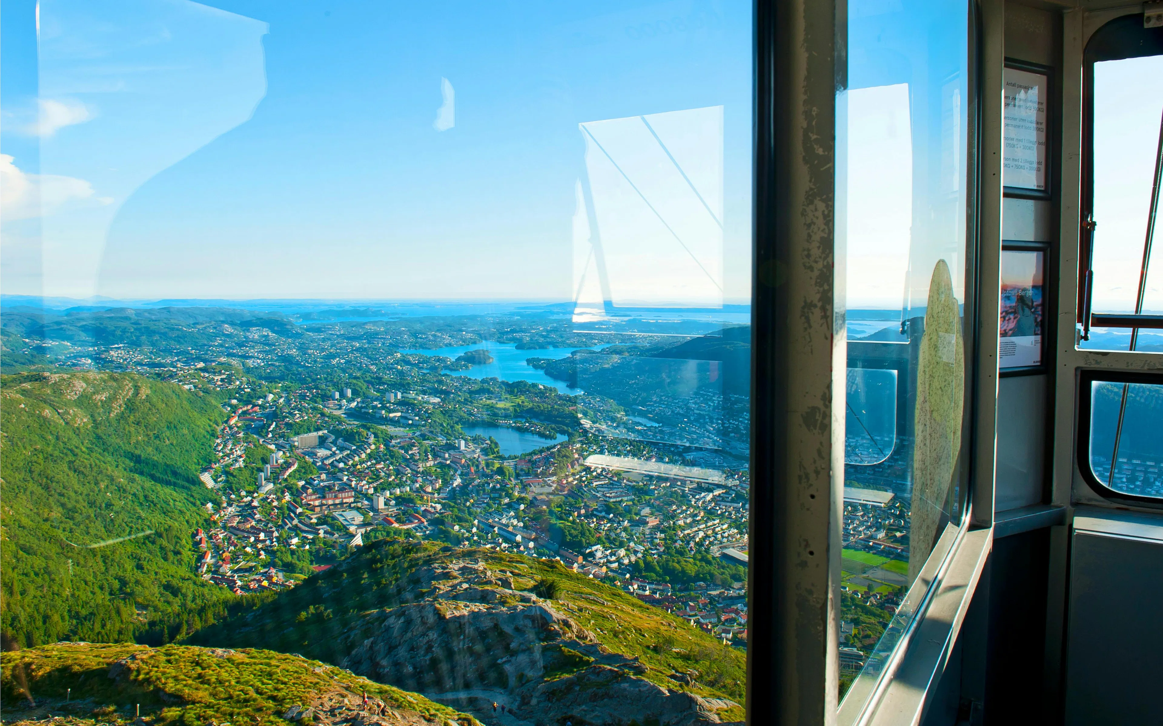 View from Ulriken Cable Car overlooking Bergen, Norway with mountains and cityscape.